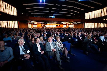 De aanwezigen luisteren naar verschillende discussies op het podium.