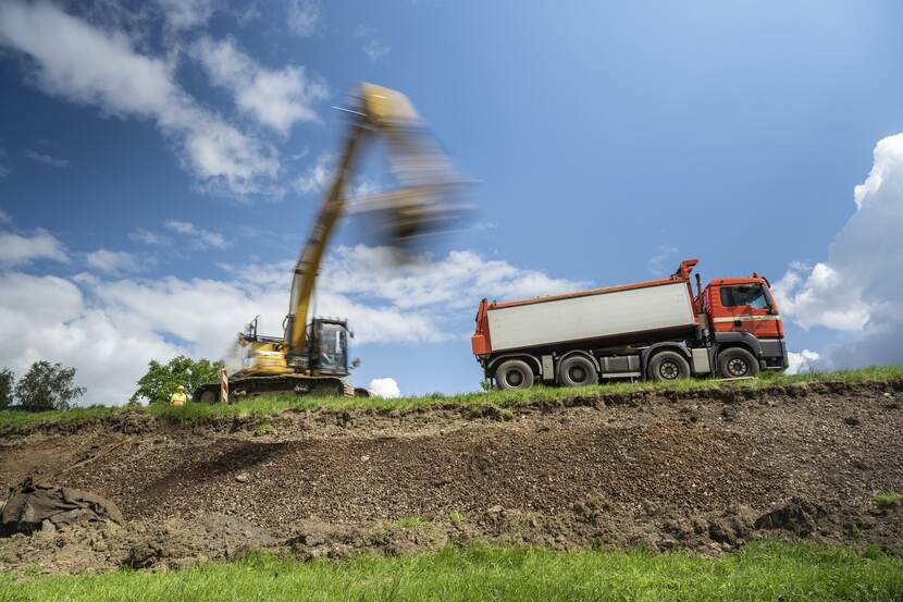 Kraan graaft een laag grond uit de dijk in Dalem (ZH) om plaats te maken voor klei. Onderdeel van dijkversterking Gorinchem-Waardenburg. Fotograaf: Tineke Dijkstra, Juli 2022