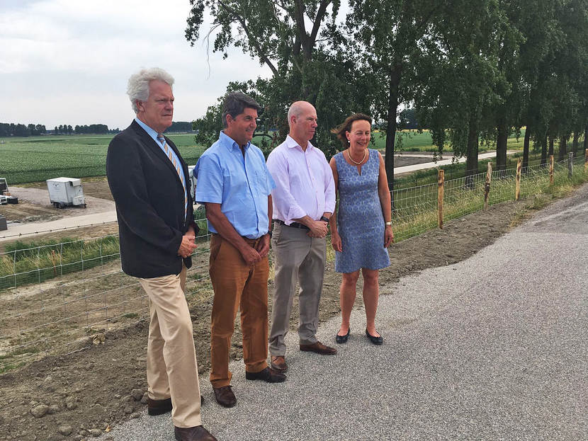 Vier mensen op een weg bij een weiland in Haringvliet