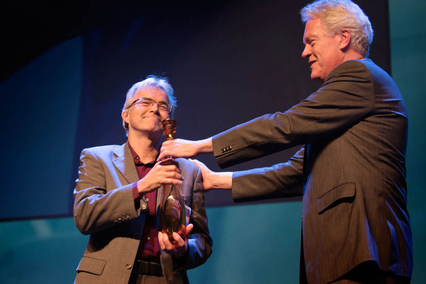 Twee mannen op het podium met een troffee