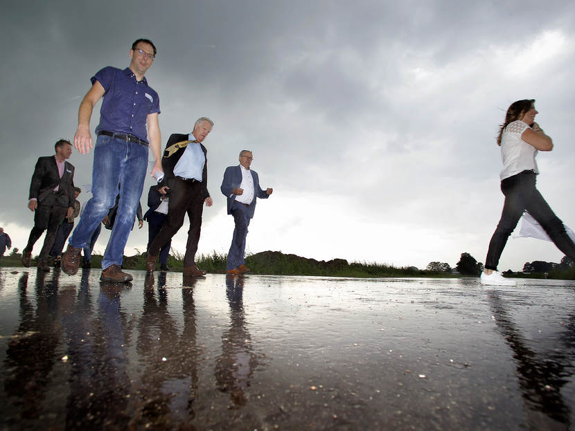 Mensen lopen over een nat geregende weg