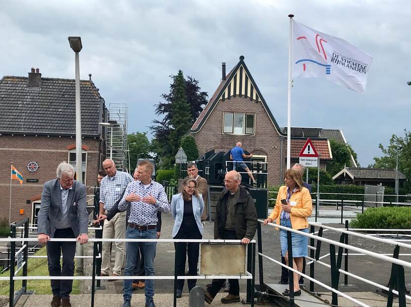 Peter Glas met anderen op een brug / sluis